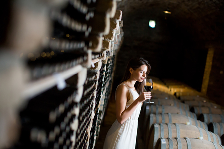Young woman in the wine cellarの写真素材