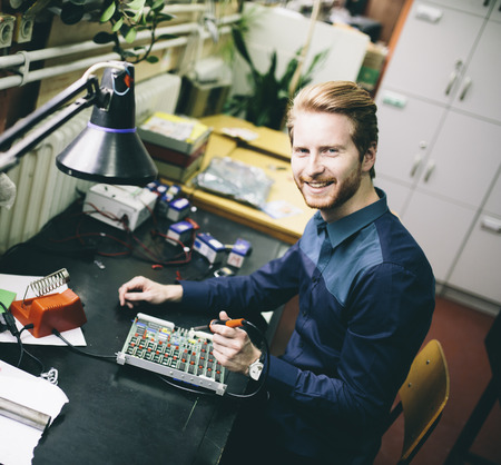 Young man in electronics workshopの写真素材