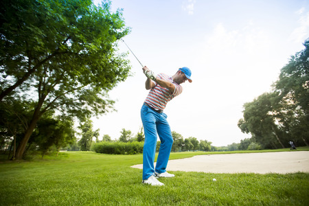 Young man playing golfの写真素材