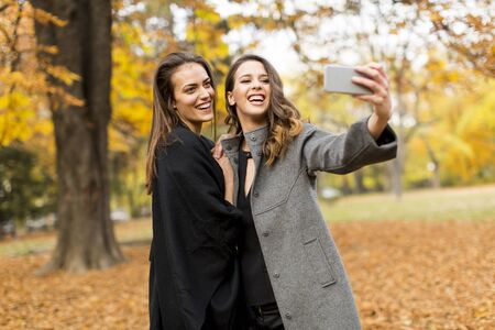Young women taking selfie with smartphone outdoorの写真素材