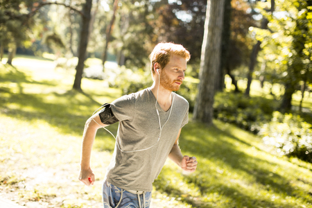 Young man running in the autumn parkの写真素材