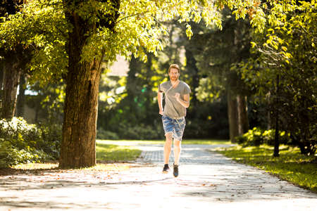 Young man running in the autumn park