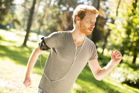 Young man running in the autumn parkの写真素材