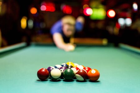 Young man playing snooker in the bar