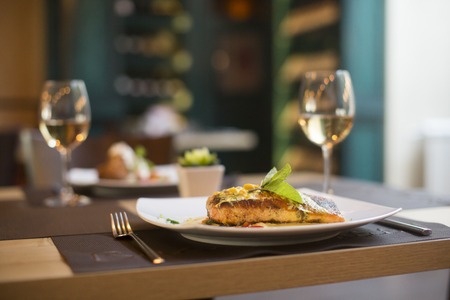 Grilled salmon with sauce and herbs served at restaurant