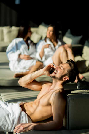 Young man in the rom with two womenの写真素材