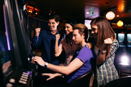 Young people at slot machine in the casino