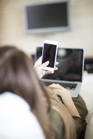Young woman with laptop and mobile phone
