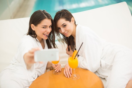 Young women taking photo by the poolの写真素材