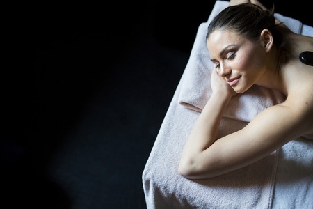 Young woman having a hot stone massage therapyの写真素材