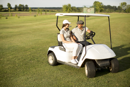 Young couple at golf cartの写真素材