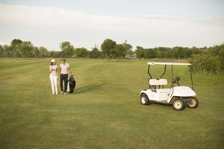 Young couple at golf cartの写真素材