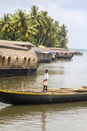 KERALA, INDIA - OCTOBER 16, 2015: Unindetified man at backwaters in Kerala, India. The backwaters are an extensive network of 41 west flowing interlocking rivers, lakes and canals that center around Alleppey, Kumarakom and Punnamada.のeditorial素材