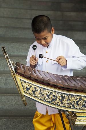 BANGKOK, THAILAND - FEBRUARY 14, 2016: Unidentified boy playing xylophone on the street of Bangkok, Thailand. Wooden xylophone called ranat is most prominent instrument in classical Thai music.のeditorial素材