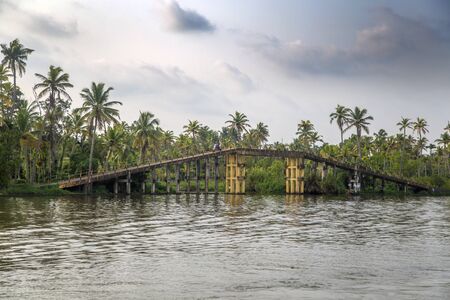 KERALA, INDIA - OCTOBER 16, 2015: Unindetified man at backwaters in Kerala, India. The backwaters are an extensive network of 41 west flowing interlocking rivers, lakes and canals that center around Alleppey, Kumarakom and Punnamada.のeditorial素材