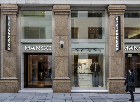 VIENNA, AUSTRIA - FEBRUARY 6, 2014: Unidentified woman in front of Mango shop n Vienna. Mango is a clothing design and manufacturing company, founded in Barcelona and have over 12.000 employees.のeditorial素材