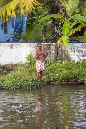 KERALA, INDIA - OCTOBER 16, 2015: Unindetified man at backwaters in Kerala, India. The backwaters are an extensive network of 41 west flowing interlocking rivers, lakes and canals that center around Alleppey, Kumarakom and Punnamada.のeditorial素材