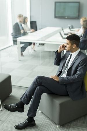 Businessman with a phone in the officeの写真素材