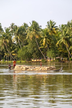 KERALA, INDIA - OCTOBER 16, 2015: Unindetified men at backwaters in Kerala, India. The backwaters are an extensive network of 41 west flowing interlocking rivers, lakes and canals that center around Alleppey, Kumarakom and Punnamada.のeditorial素材
