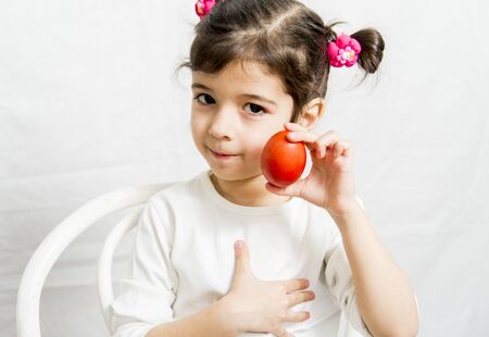 Little girl with a red Easter eggの写真素材