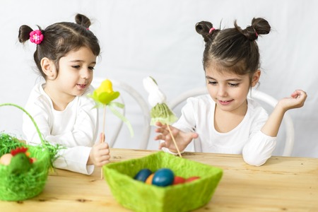 Two joyful little girls with Easter eggsの写真素材