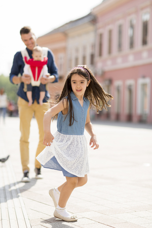 Father with a daughter and a baby walking on the streetの写真素材