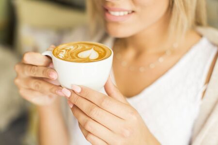 Closeup of the woman holding a cup of coffeeの写真素材