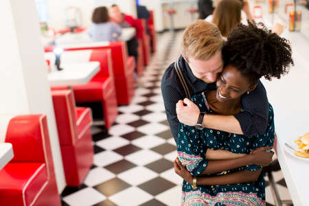 Couple hugging by the bar in the dinerの写真素材