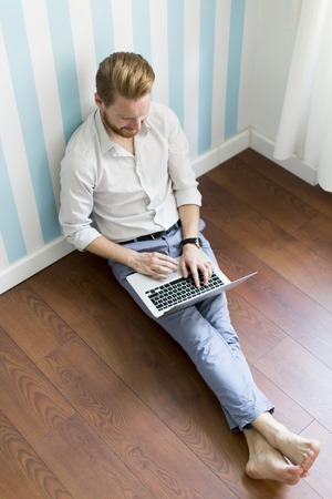 Man with the laptop sitting on the floorの写真素材