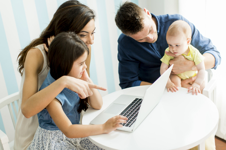 Family with the laptop at the tableの写真素材