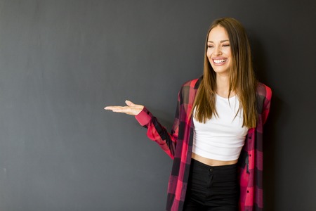 Pretty young woman by the black wallの写真素材