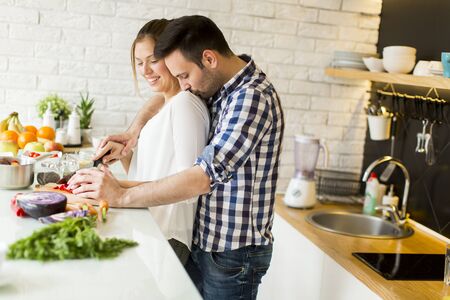 Loving couple preparing healthy food in modern kitchenの写真素材