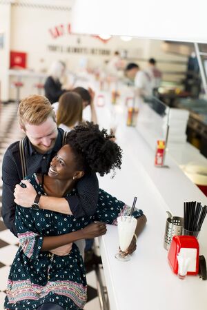 Couple hugging by the bar in the dinerの写真素材