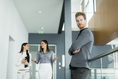 Young redhead man in the office with women colleaguesの写真素材