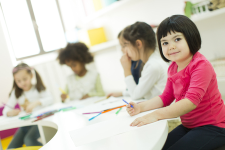 Little girls drawing and learning in the kindergartenの写真素材