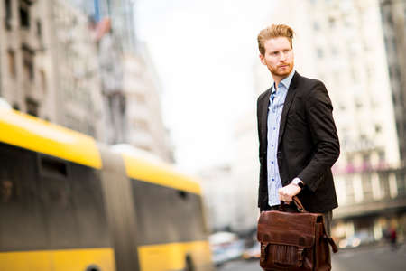 Young businessman standing on the streetの写真素材