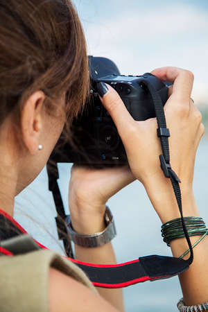 Charming woman using a cameraの写真素材