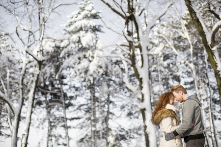 Loving young couple at winter forestの写真素材