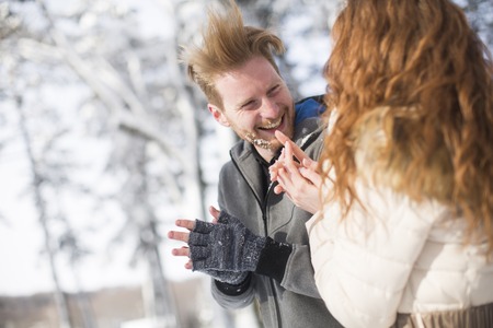 Young couple having fun in the snow in the parkの写真素材