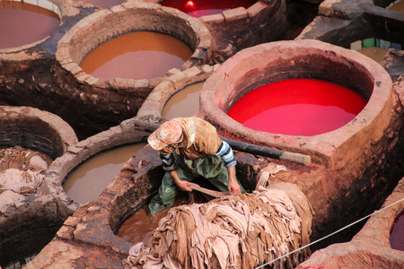 FES, MOROCCO - DECEMBER 12, 2014: Unidentified man working at tannery in Fes, Morocco. This is the oldest leather tannery in the world and has not changed since the 11th century.のeditorial素材
