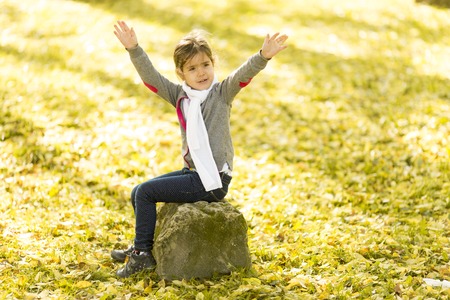Cute little girl in the park at autumnの写真素材