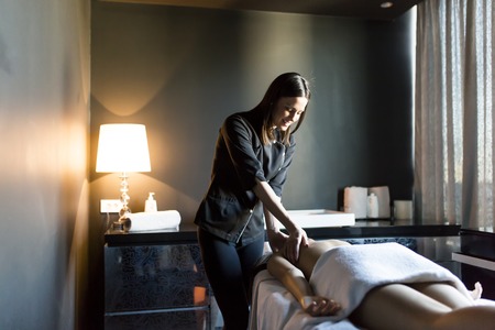 Pretty young woman having a massage in wellness centerの写真素材