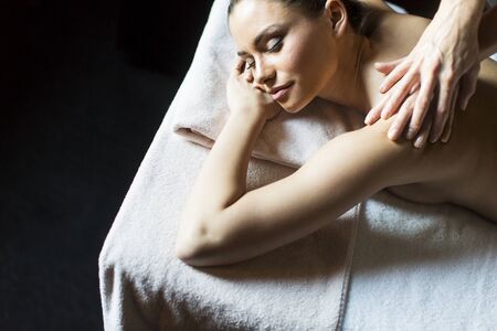 Pretty young woman having a massage in wellness centerの写真素材