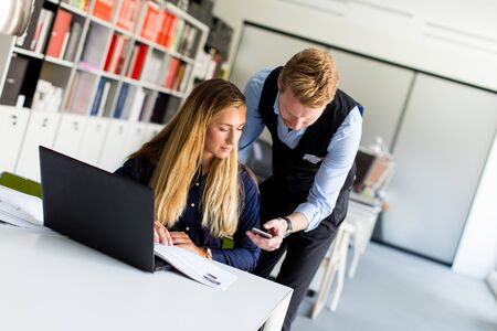 Young business couple using laptop in the officeの写真素材