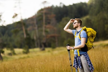 Young man enjoys hiking on a sunny day