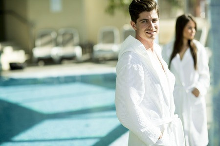 Loving young couple taking selfie with mobile phone by the poolの写真素材