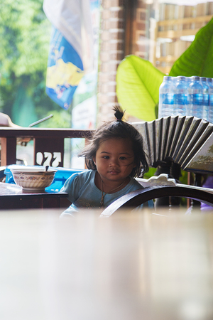 KO PHA NGAN - FEBRUARY 6, 2016: Unidentified girl in restaurant at Ko Pha Ngan island in Thailand. Island is part of the Samui Archipelago and is famous  backpacker destination.のeditorial素材