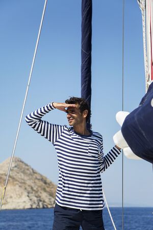 Young man on a sailing ship looks into the distance