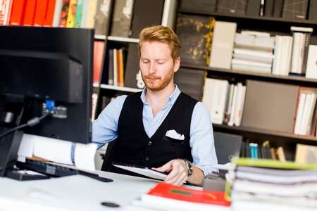 Successful young businessman at desk in officeの写真素材