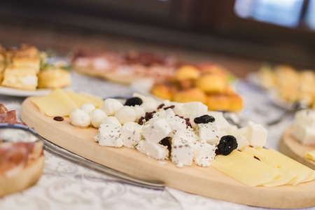 Various cheese pieces on the wooden plateの写真素材
